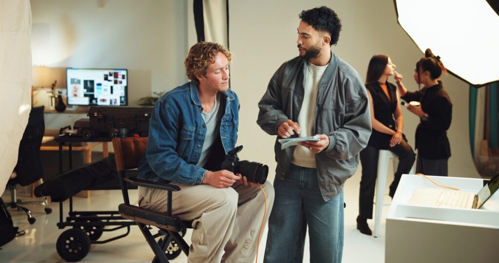 Talking, photographer and people with tablet in studio for editing software, photoshoot and product